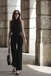 a lady wears a black halter top and a flared black pants